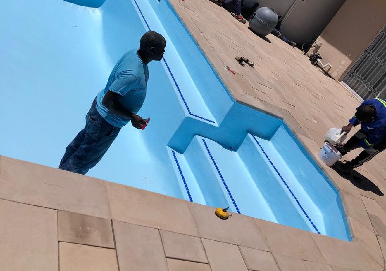 Pool relining Cape Town - freshly relined blue pool with crew at work