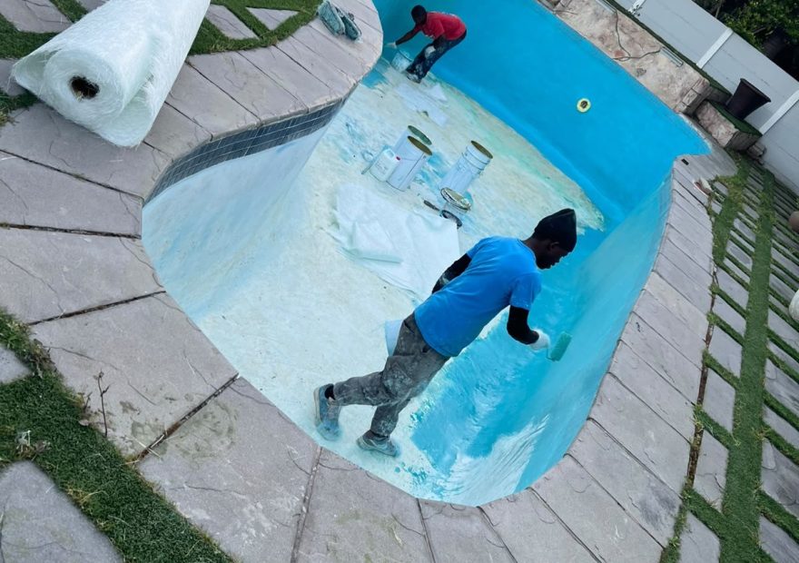 Fibreglass lining being rolled onto the gunite pool floor in Kuilsriver