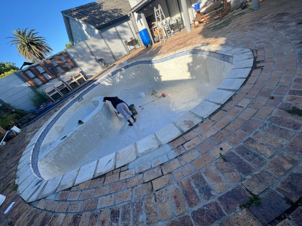 Gunite pool relining Kraaifontein: drained 7x5m pool with loose, delaminated old fibreglass before the reline