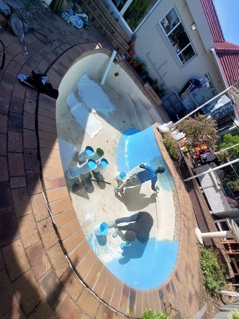 Pool repairs Rondebosch: crew applying fibreglass to an old gunite pool